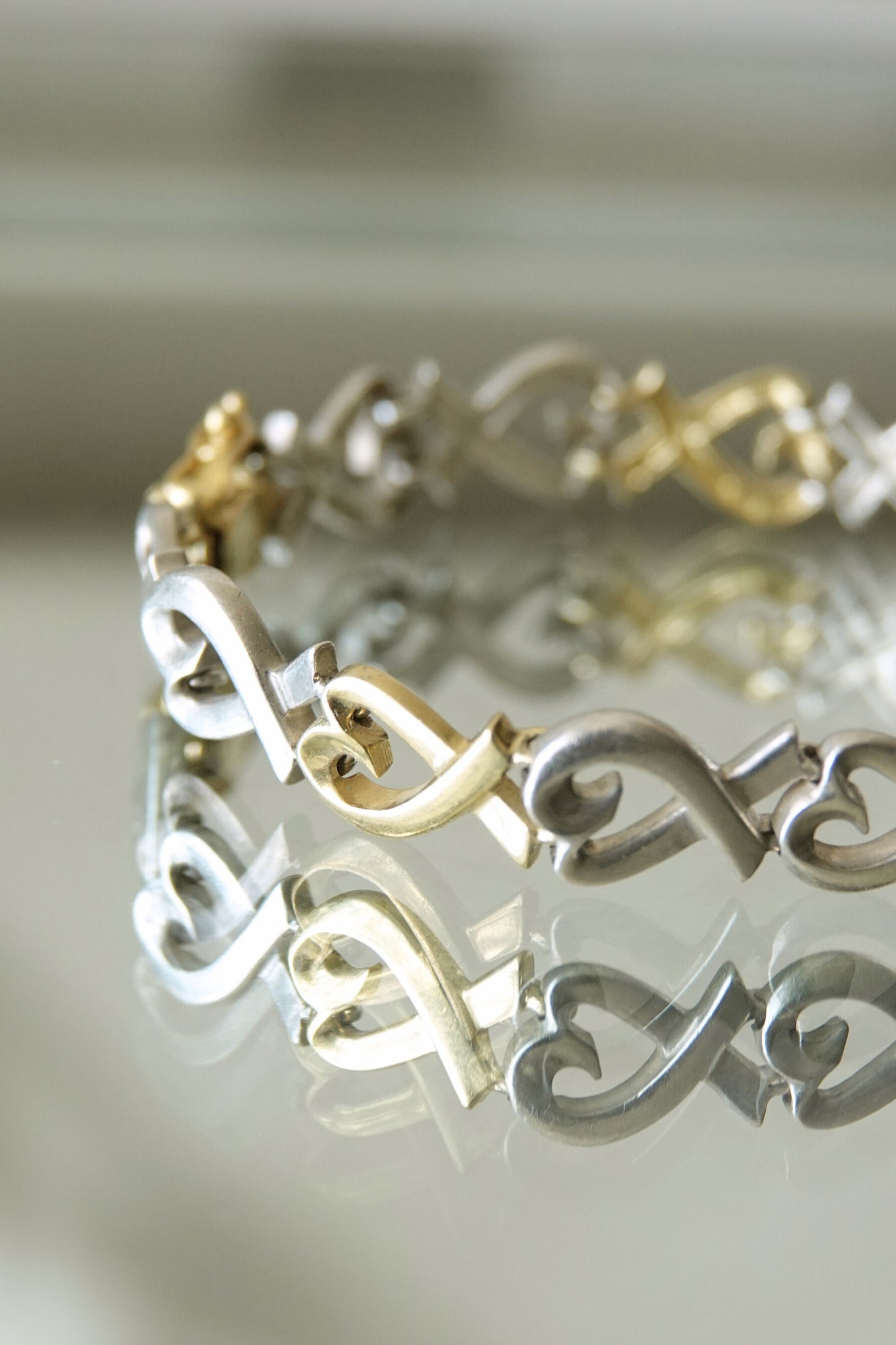 Paloma Picasso for Tiffany & Co. Loving Heart link bracelet: angled view highlighting the dimensional quality of the heart links and the warm gold against cool silver tones