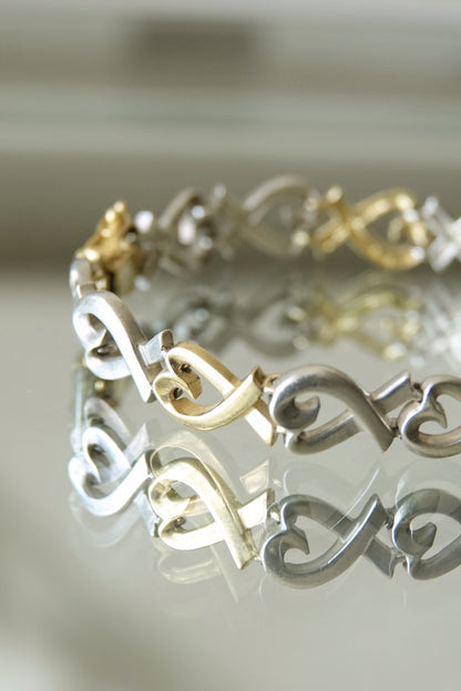 Paloma Picasso for Tiffany & Co. Loving Heart link bracelet: angled view highlighting the dimensional quality of the heart links and the warm gold against cool silver tones