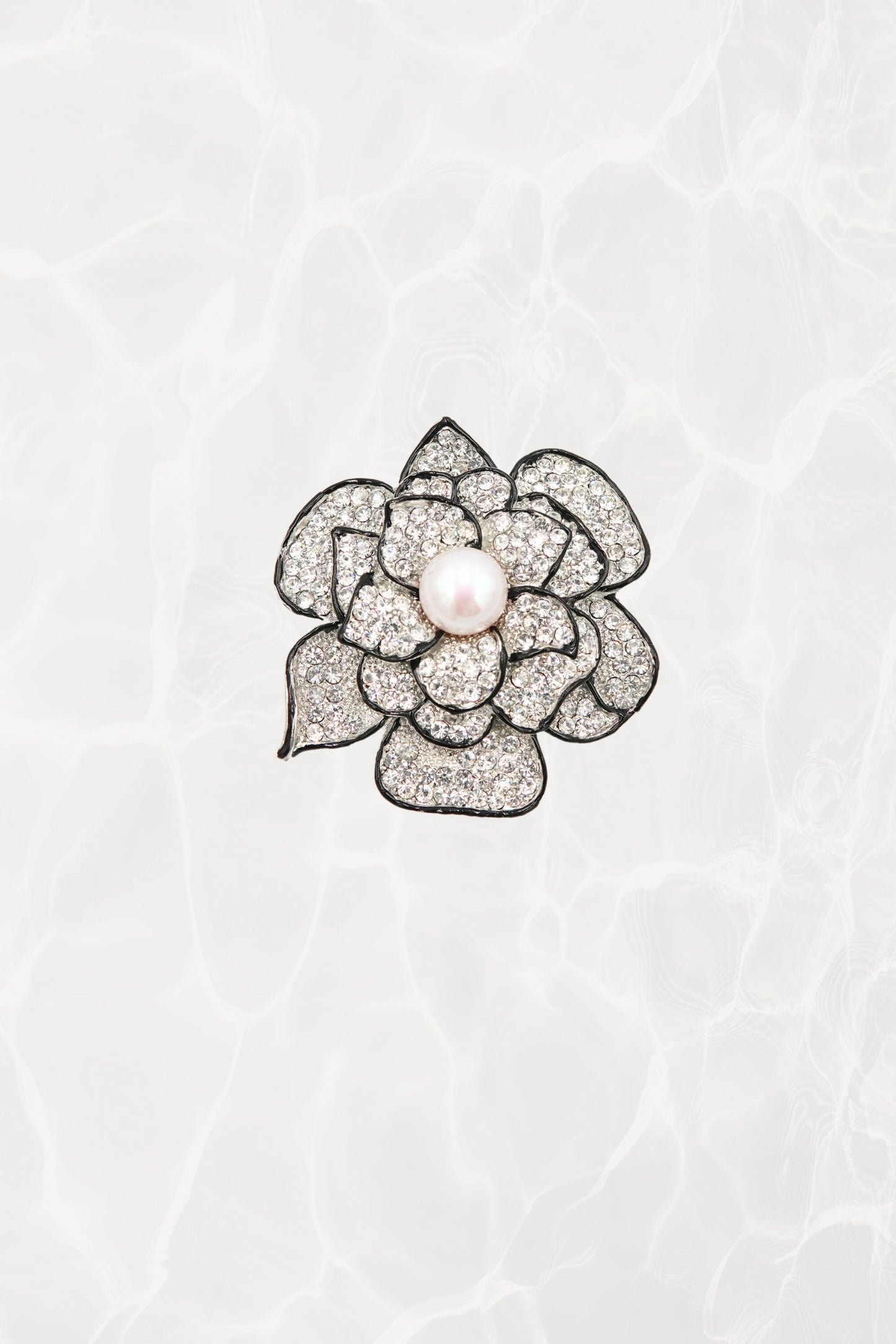 Pavé rhinestone camellia brooch with faux pearl center — hero front view