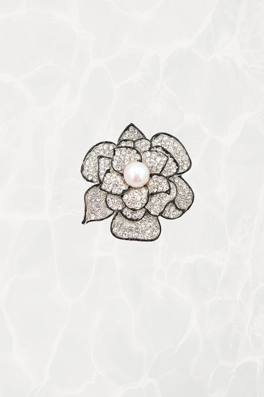 Pavé rhinestone camellia brooch with faux pearl center — hero front view