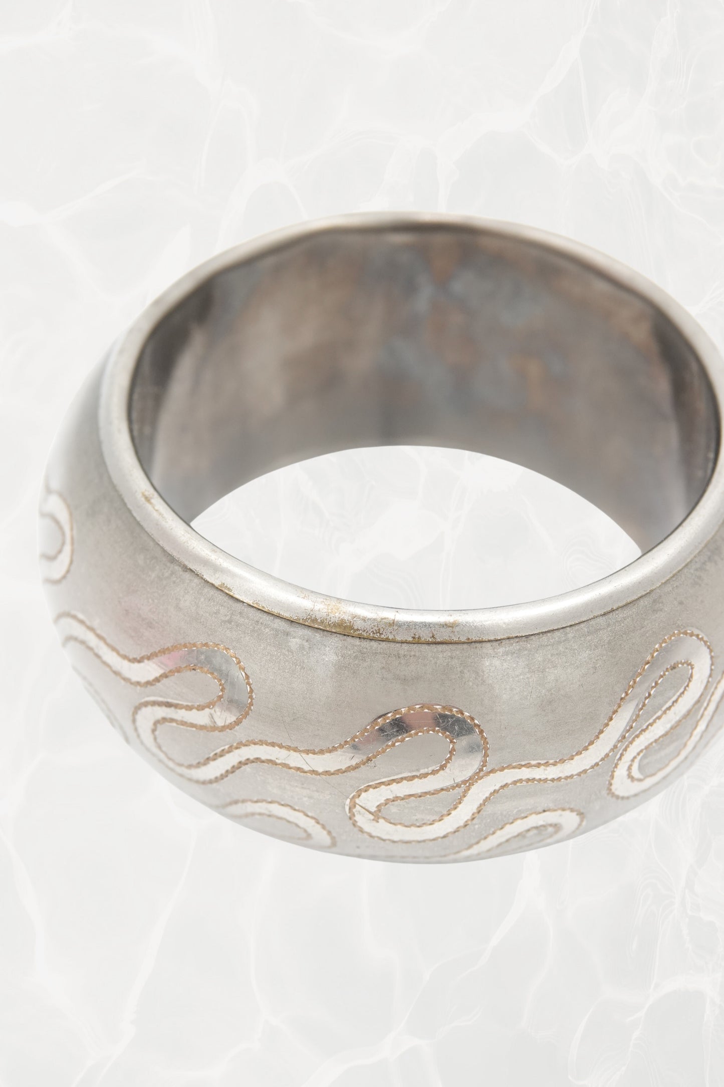 Serpentine etched bangle — close-up of enamel inlay detail