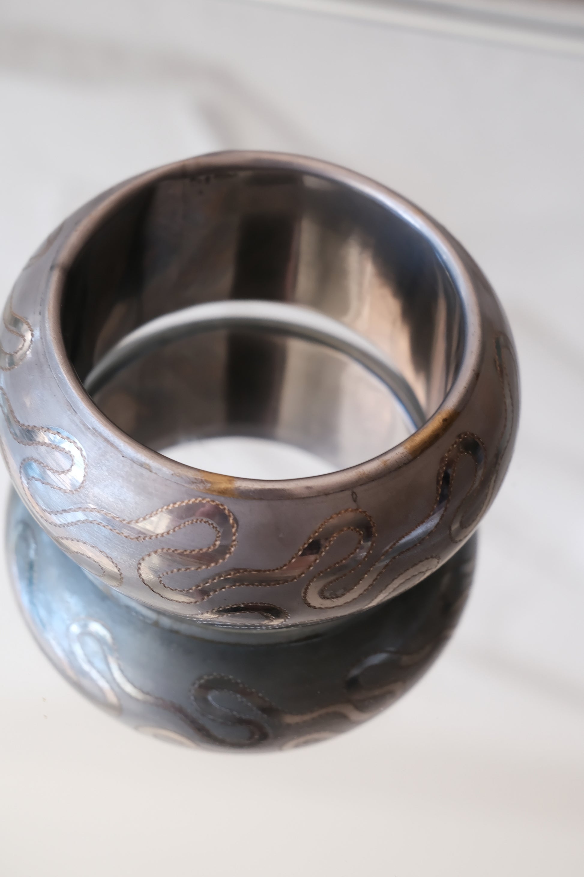 Vintage etched serpentine bangle, angled top view showing serpentine motif — Disco Palma