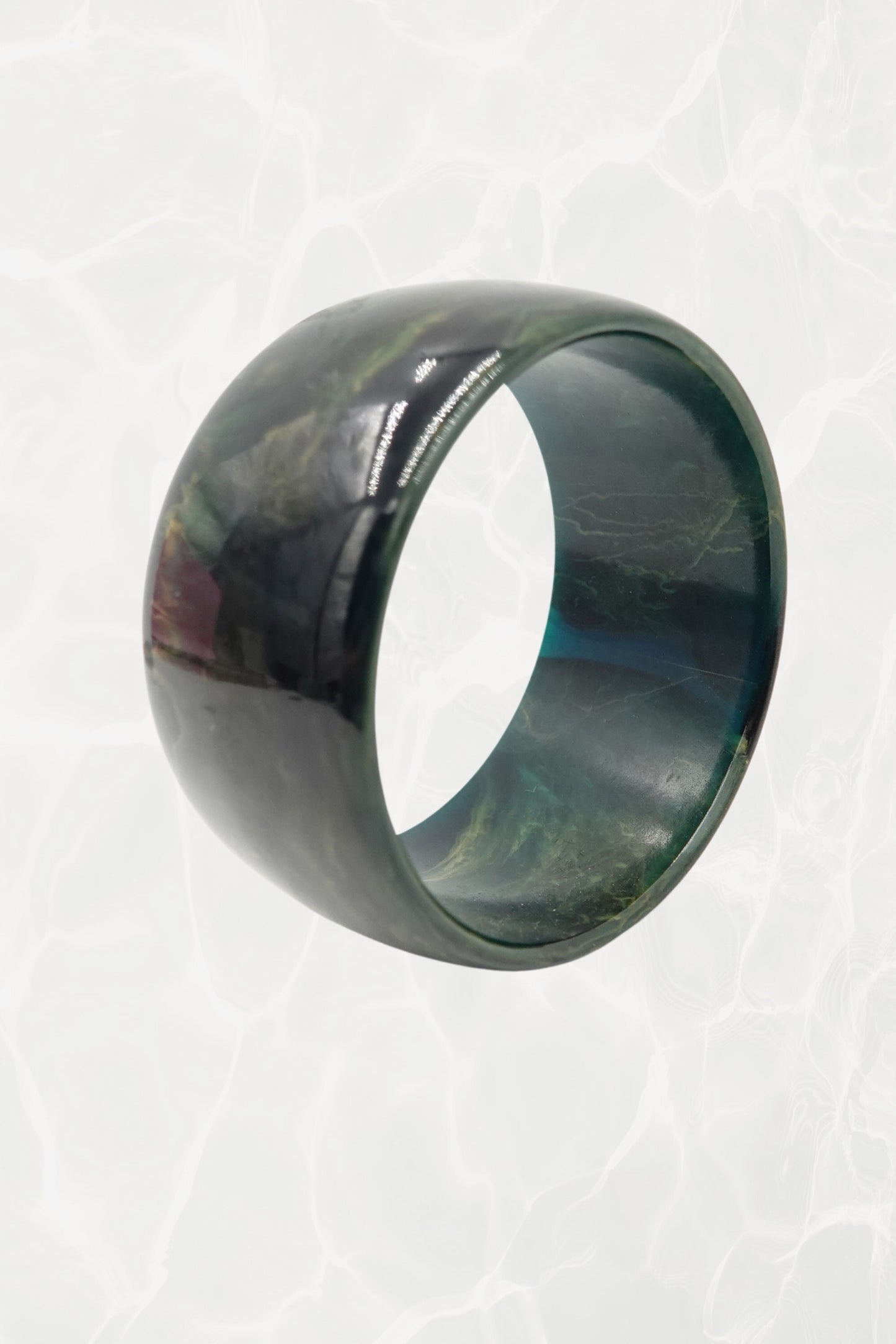 Wide green marbled resin bangle — three-quarter view