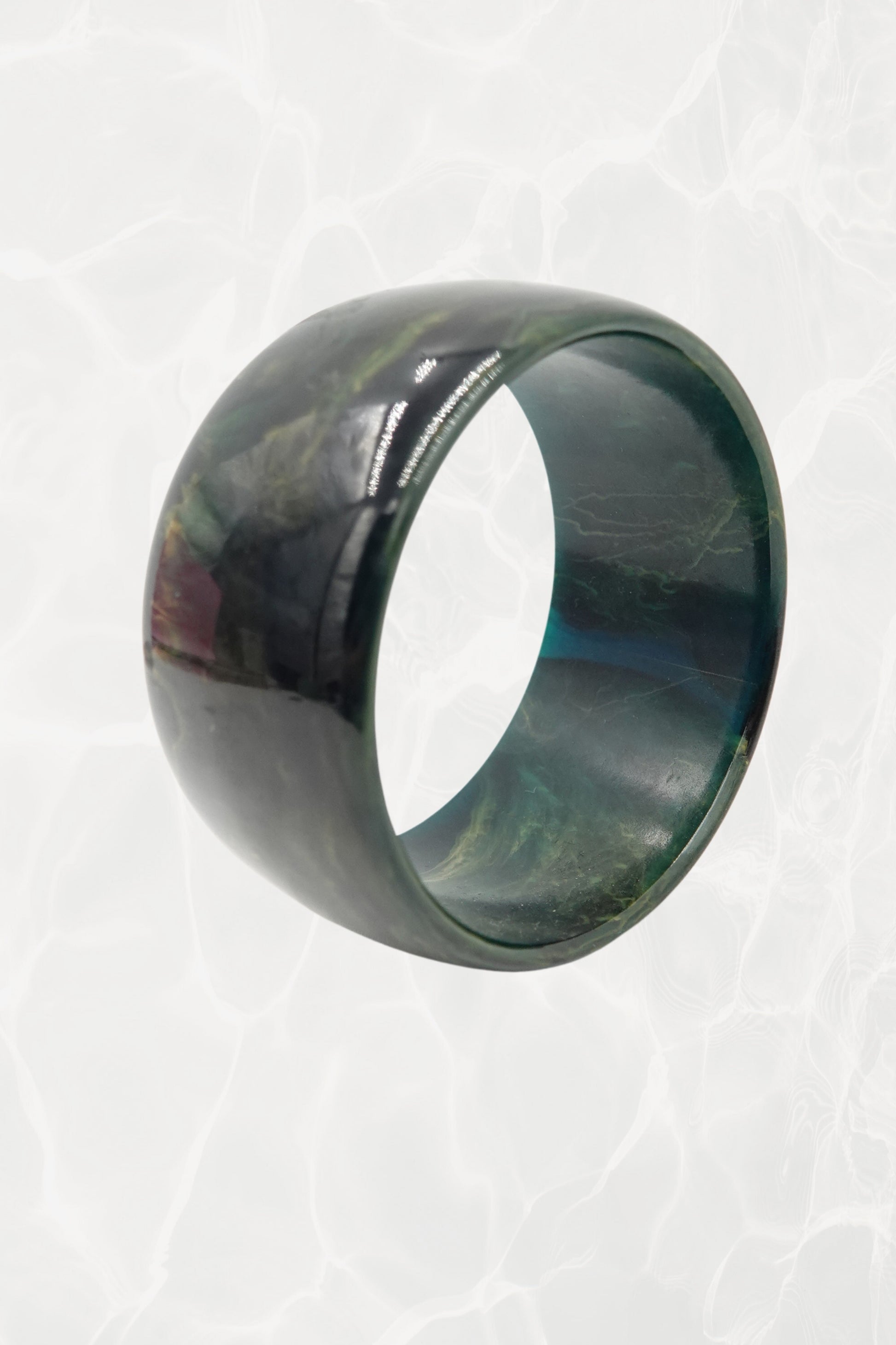 Wide green marbled resin bangle — three-quarter view