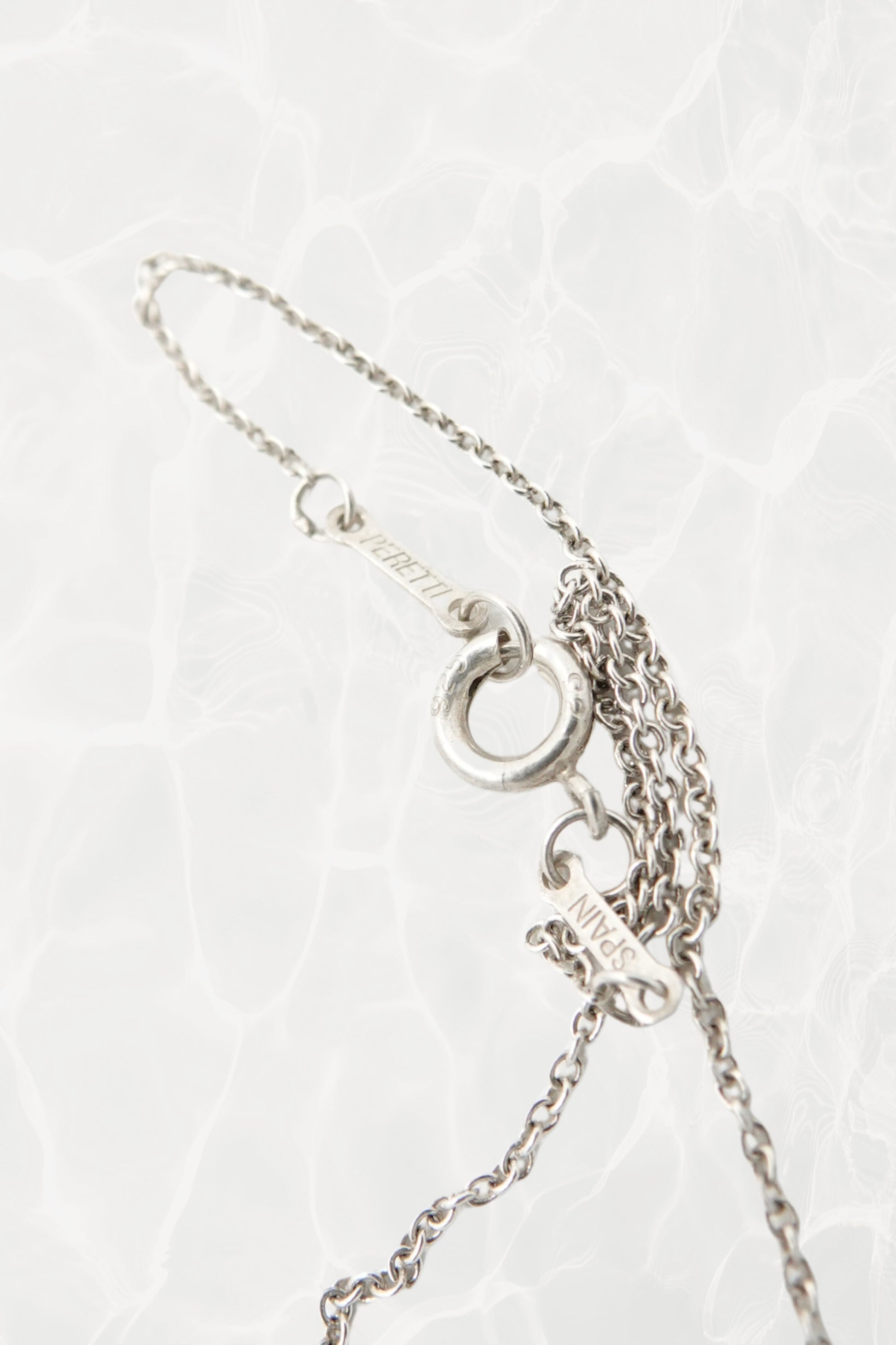 Elsa Peretti for Tiffany & Co. sterling silver starfish necklace hallmark detail: close-up of Tiffany & Co. and Elsa Peretti sterling silver 925 hallmark engraving on pendant reverse