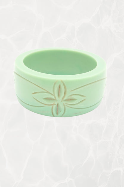Carved celadon Bakelite bangle — side view showing botanical motif
