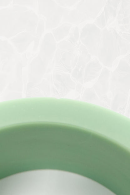 Mint green Bakelite bangle — close-up of carved botanical pattern