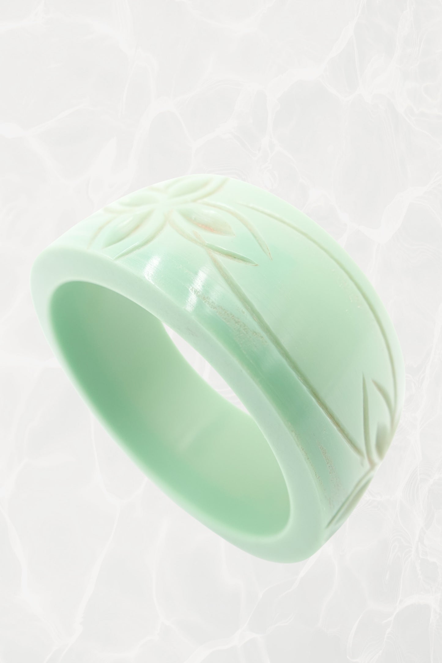 Mint Bakelite bangle — angled three-quarter view with carved motif
