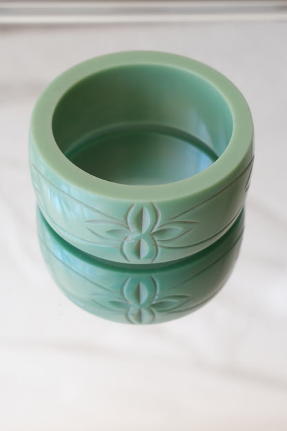Vintage Bakelite bangle, carved botanical motif front view — styled on reflective marble — Disco Palma