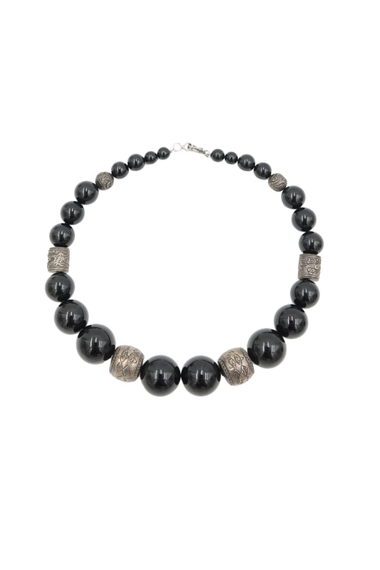 Vintage 1980s black onyx beaded necklace with engraved silver spacers — full length on white