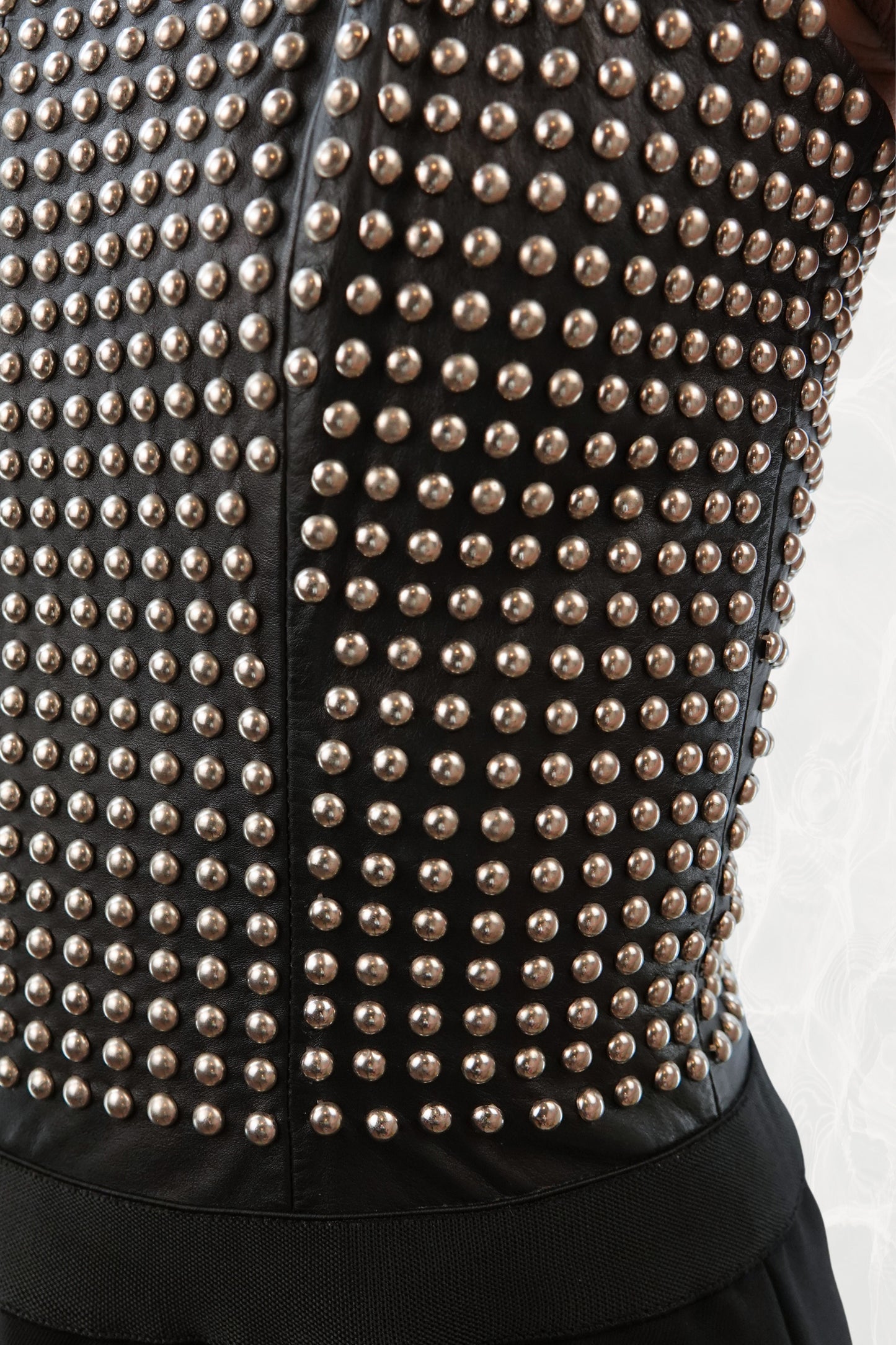 Loewe by Narciso Rodriguez AW01 studded leather dress detail: close-up of all-over metal stud embellishment covering the fitted leather corset bodice, dense studded texture with elastic shoulder strap, AW2001