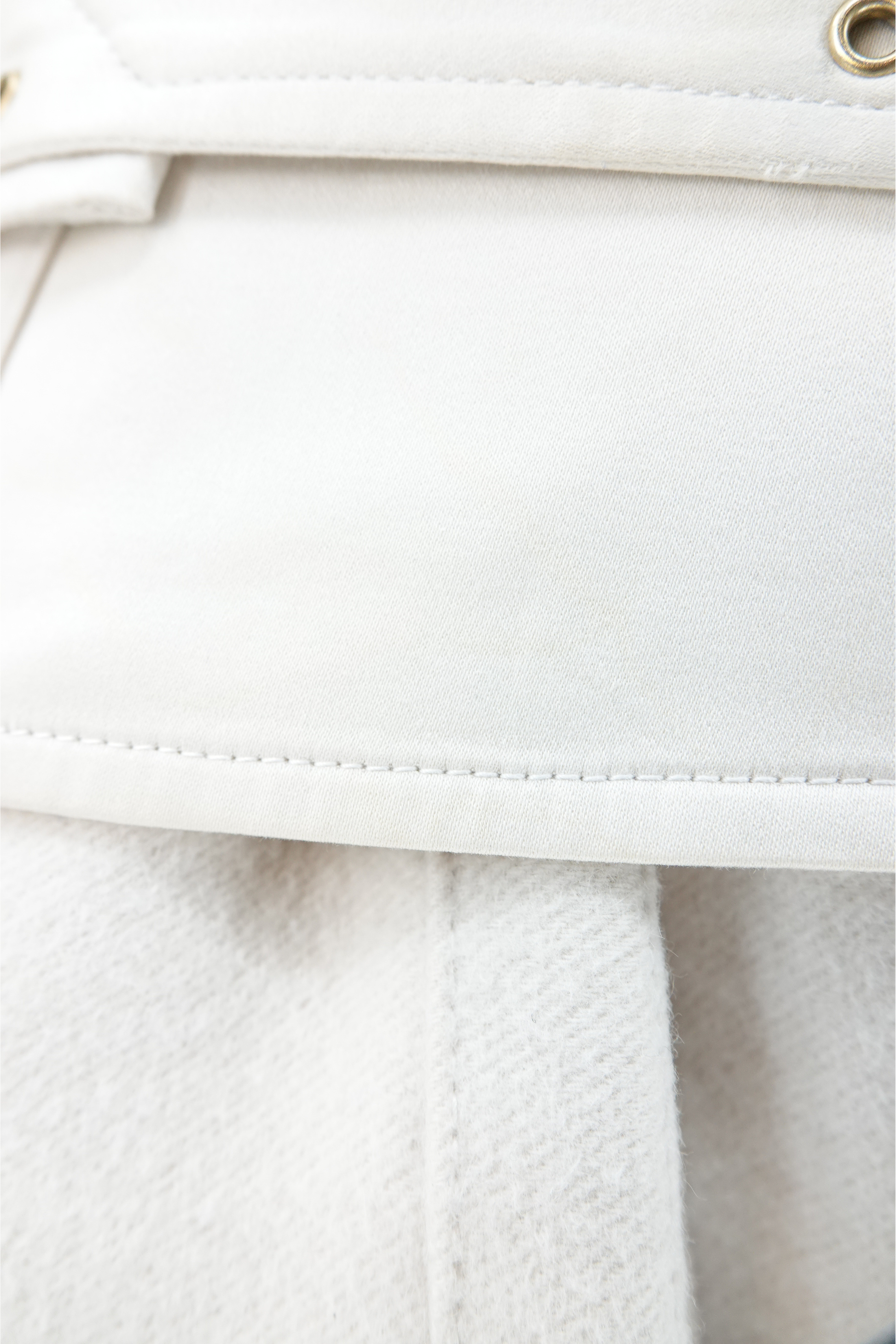 Tom Ford for Gucci AW03 white wool angora coat fabric detail: close-up of white wool angora texture with topstitched seam and gold brass stud eyelet on corset belt, Fall Winter 2003