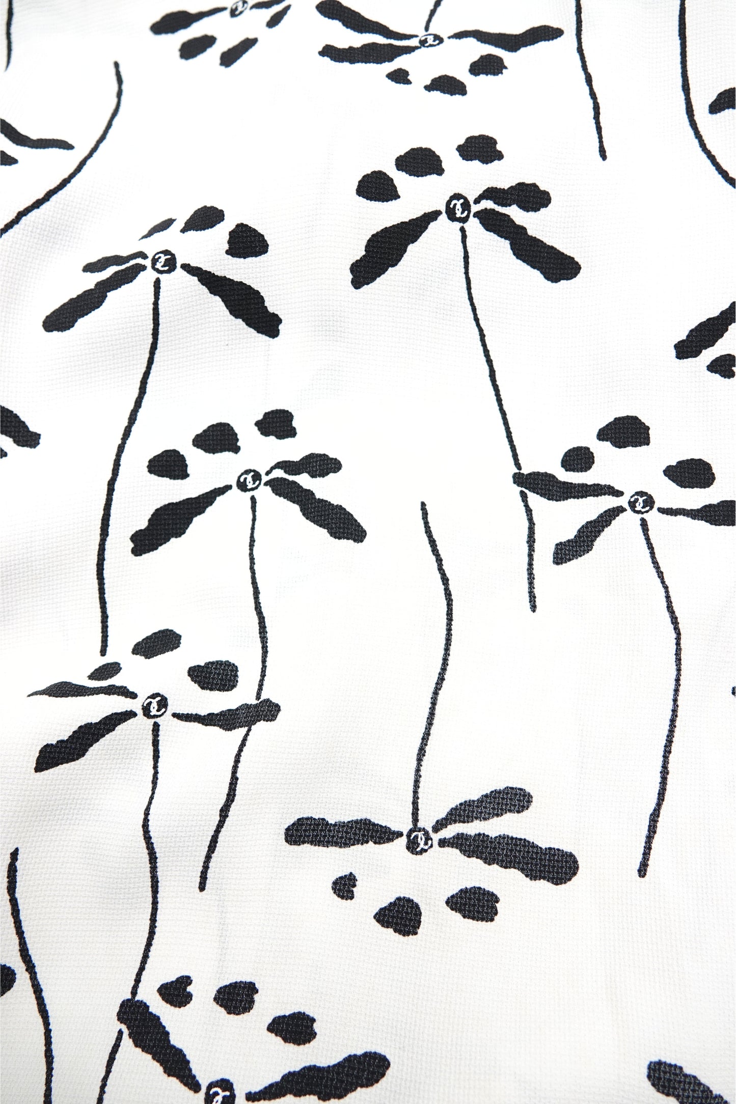 Chanel 98P dragonfly print base fabric close-up: black dragonfly and botanical stem print on white woven base fabric, shown flat, Chanel Spring 1998 print detail