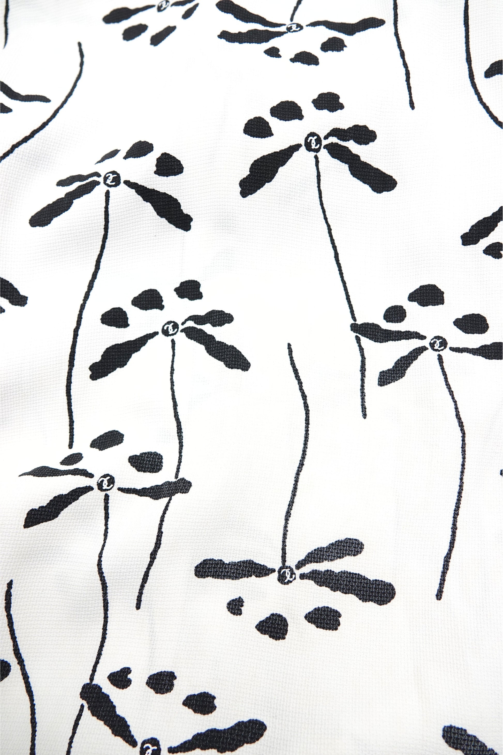Chanel 98P dragonfly print base fabric close-up: black dragonfly and botanical stem print on white woven base fabric, shown flat, Chanel Spring 1998 print detail