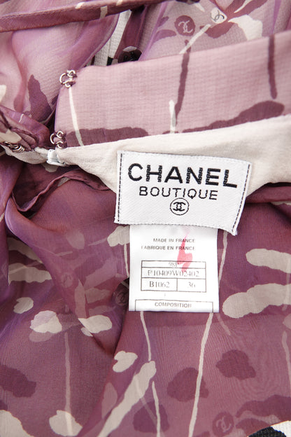 Chanel 98P authentication label close-up: white "Chanel Boutique" woven label with CC interlace logo, "Made in France" care label, on mauve dragonfly print silk chiffon, 1998