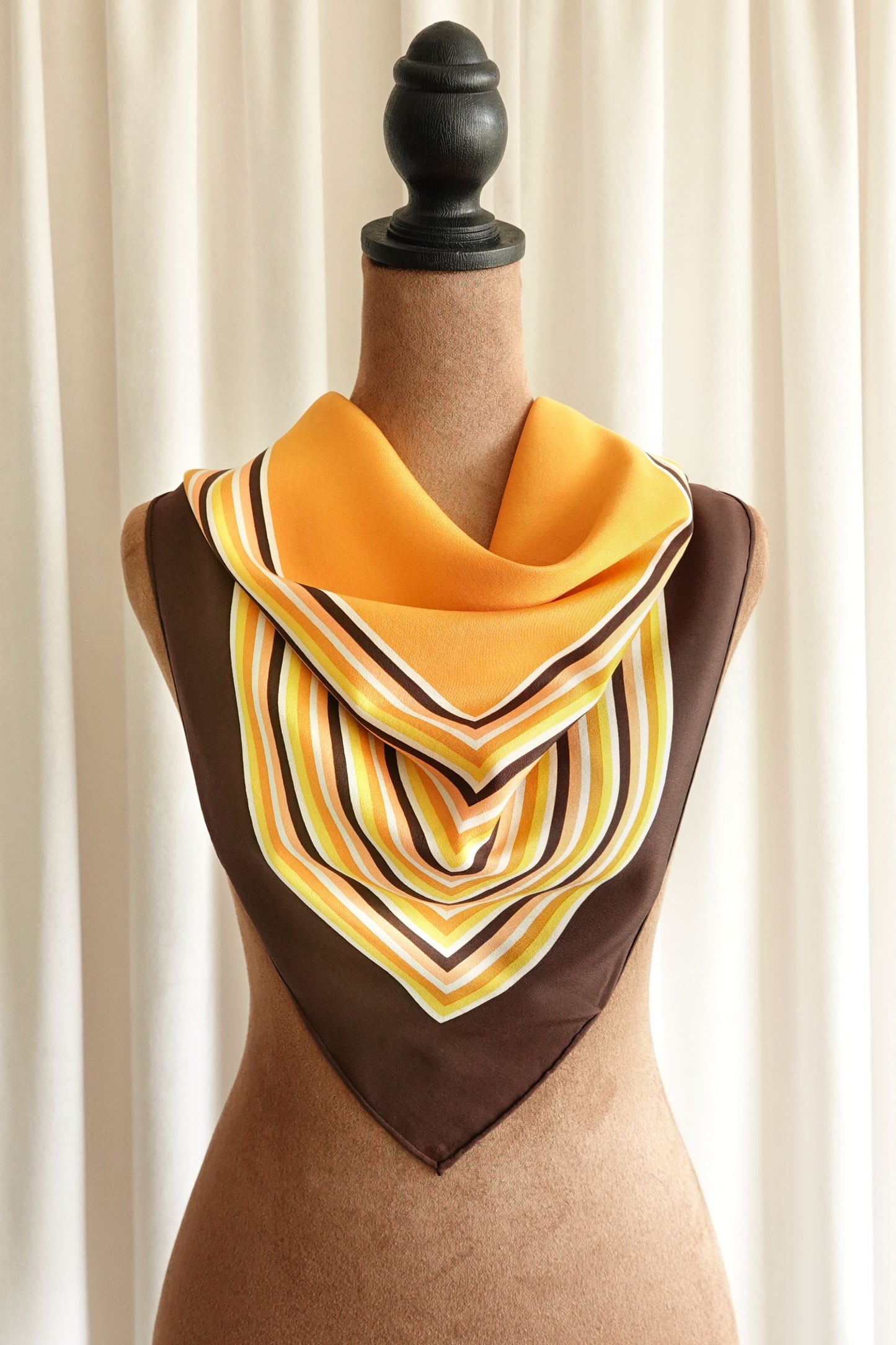 1970s YSL Yves Saint Laurent silk scarf: close-up detail of the concentric square stripe border showing the warm brown and orange color palette and fine silk weave