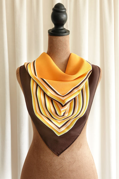 1970s YSL Yves Saint Laurent silk scarf: close-up detail of the concentric square stripe border showing the warm brown and orange color palette and fine silk weave
