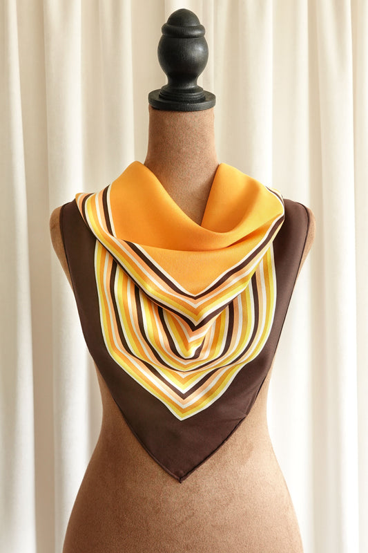 1970s YSL Yves Saint Laurent silk scarf: close-up detail of the concentric square stripe border showing the warm brown and orange color palette and fine silk weave
