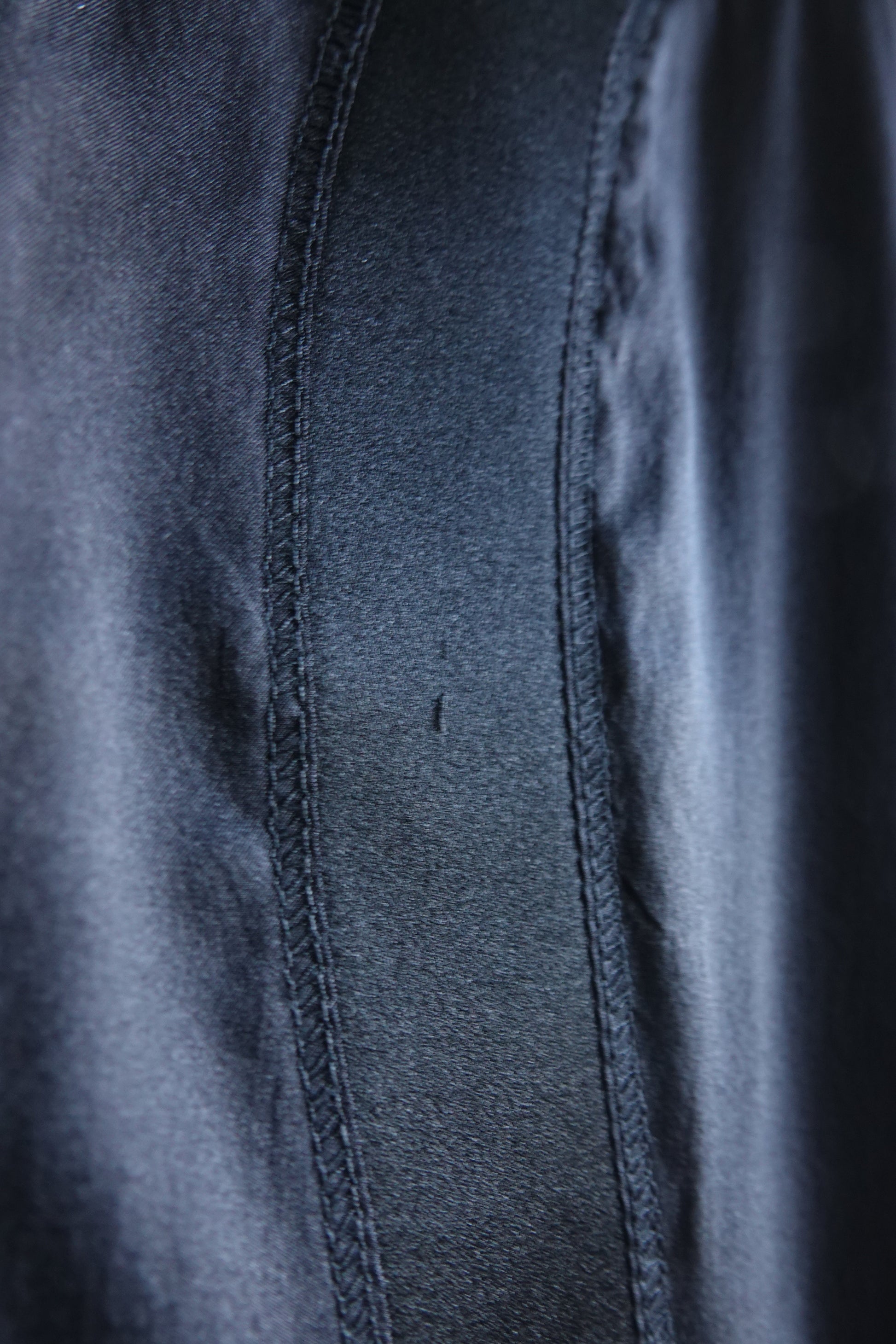Tom Ford for Gucci FW03 black silk skirt condition detail: extreme close-up of topstitched seam on satin panel showing small snag, disclosed condition detail, Fall 2003