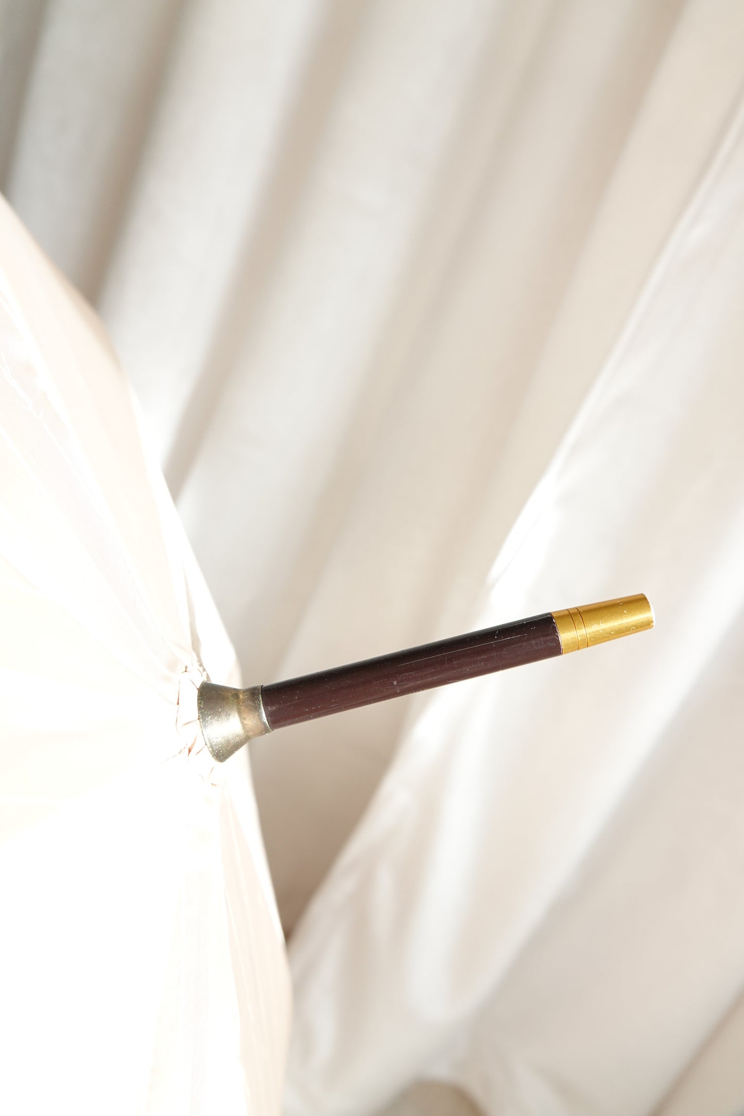 Vintage YSL Yves Saint Laurent gold umbrella: detail of the umbrella tip and lower shaft showing the gold-tone finish and overall quality of the vintage piece