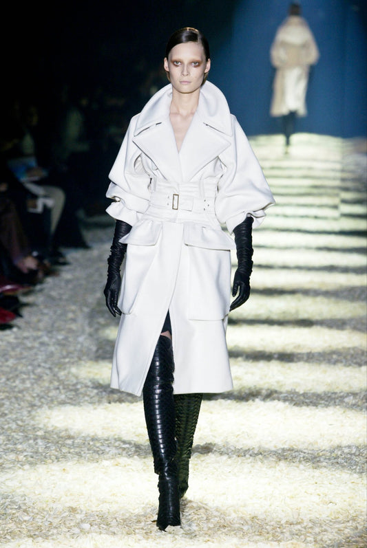 Tom Ford for Gucci AW03 white wool angora corset coat on runway: opening look with oversized collar, corset belt, black over-the-knee boots and long gloves, Gucci Fall Winter 2003