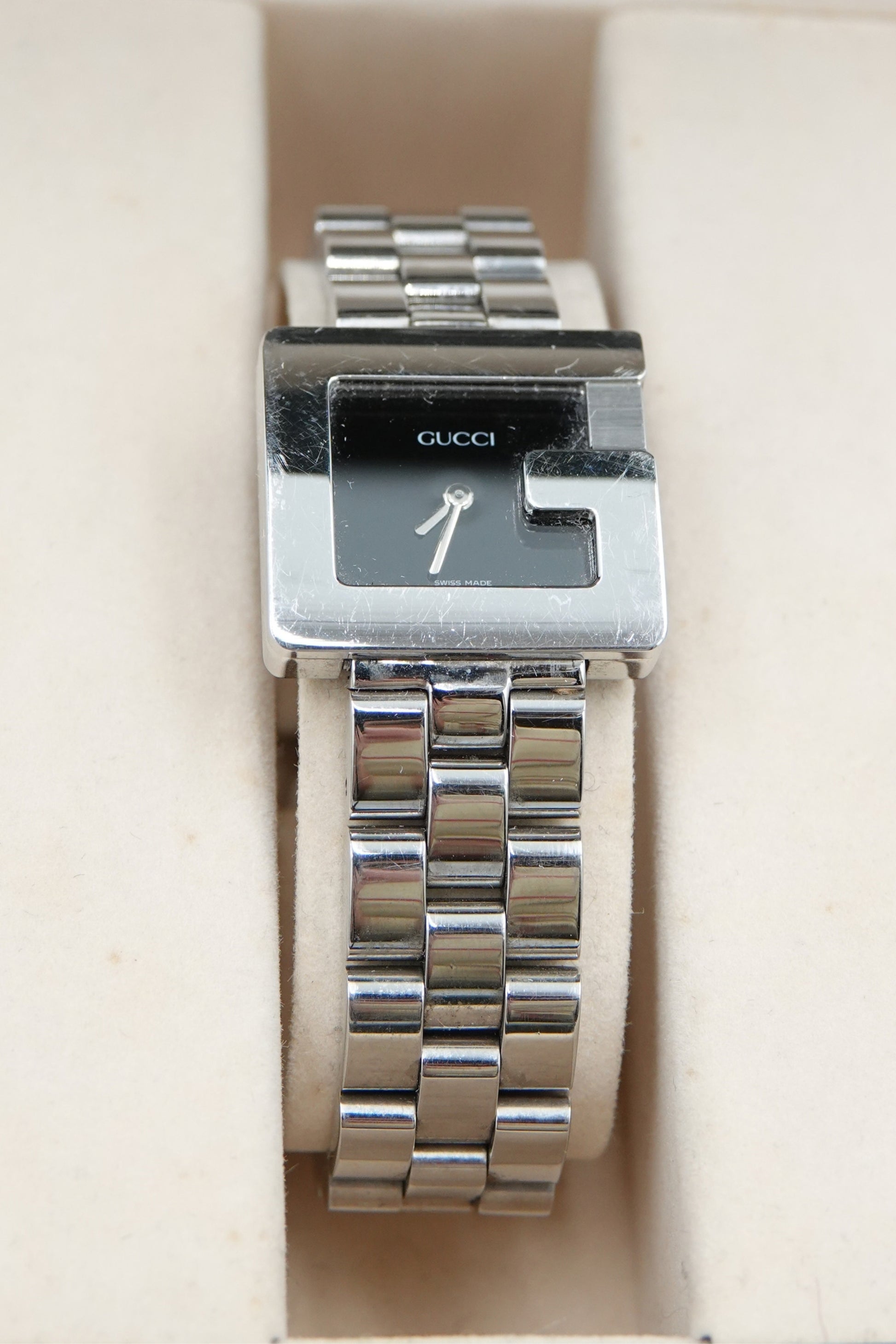 Tom Ford for Gucci G-Frame watch dial close-up showing crystal surface and silver baton hands