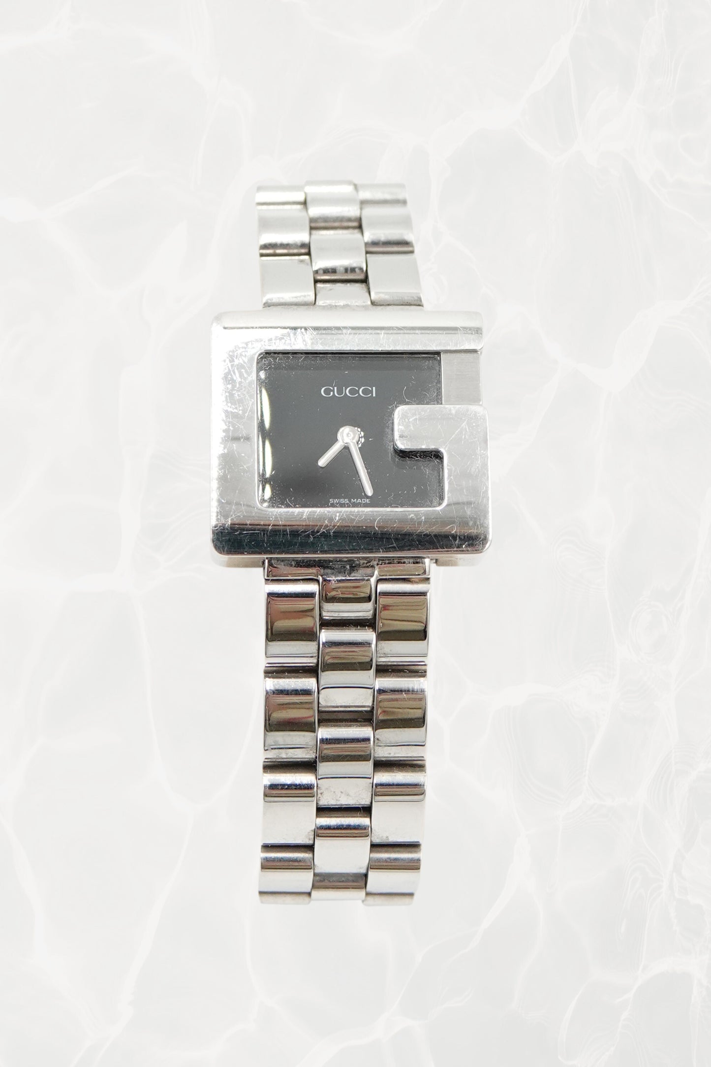 Tom Ford for Gucci G-Frame stainless steel watch, front view — black dial with silver baton hands and G-shaped bezel