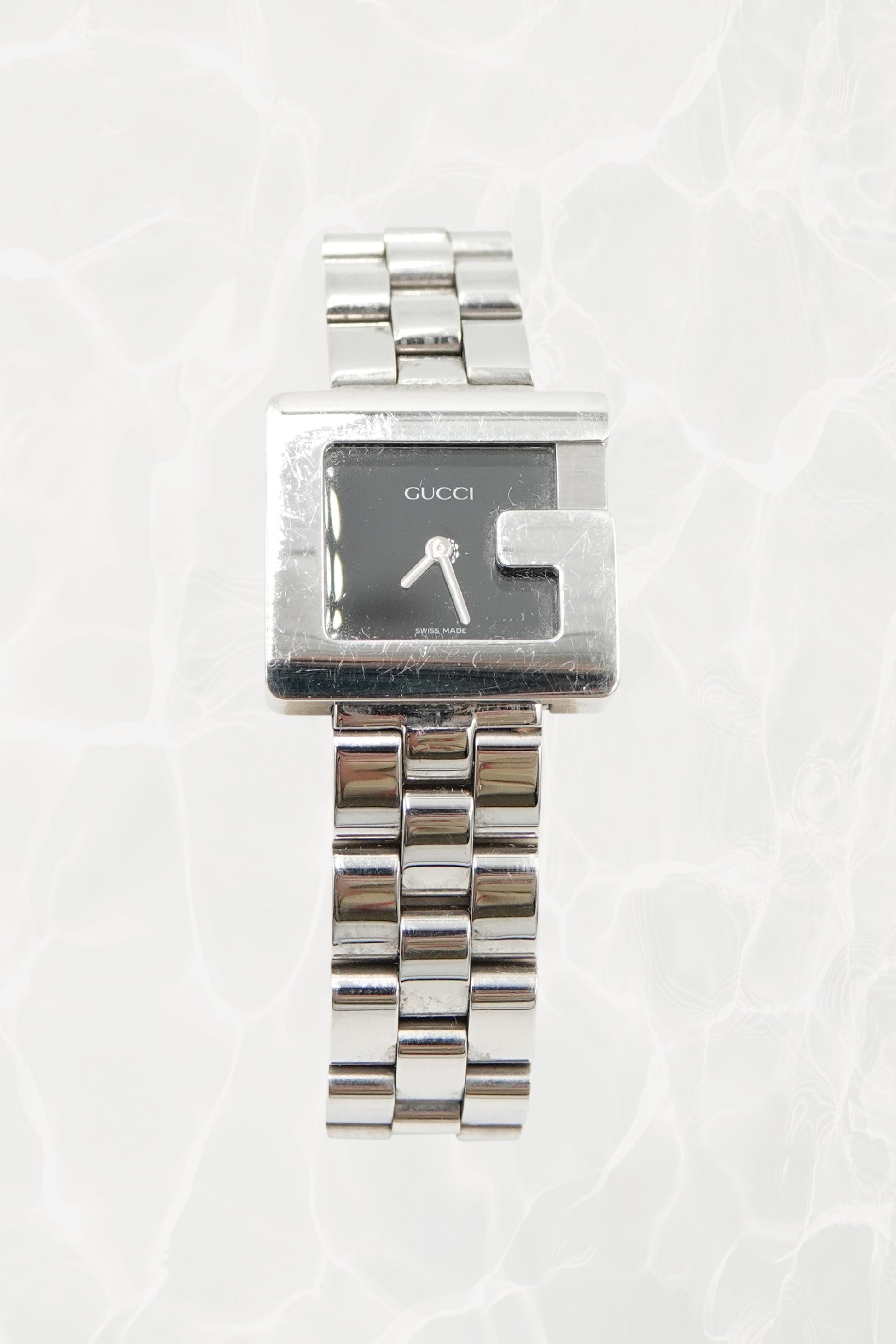 Tom Ford for Gucci G-Frame stainless steel watch, front view — black dial with silver baton hands and G-shaped bezel