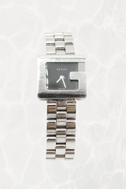 Tom Ford for Gucci G-Frame stainless steel watch, front view — black dial with silver baton hands and G-shaped bezel